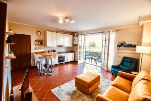 een woonkamer met een bank en een keuken bij Angolo Paradiso - Casa vacanze sui campi da golf in Fubine