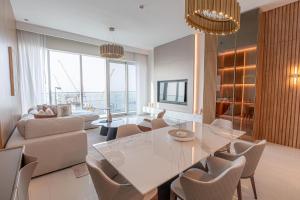 uma sala de estar com uma mesa de vidro e cadeiras em Avani Plus Palm View Dubai Suites no Dubai
