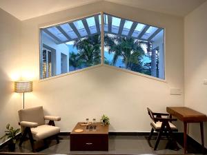 un soggiorno con una grande finestra e un tavolo di Sukoon Boutique Stays, Yelagiri a Yelagiri