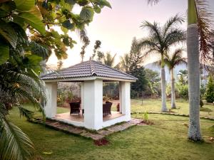 un gazebo in un cortile con palme di Sukoon Boutique Stays, Yelagiri a Yelagiri