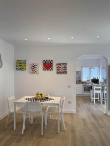 a white dining room with a white table and chairs at Donna Antonietta in Sant'Agnello
