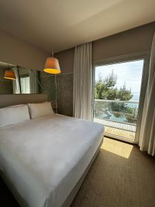 a bedroom with a large bed and a large window at Hotel Miramare - Adults Only in Trieste
