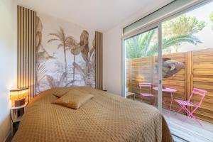 een slaapkamer met een bed en een groot raam bij domaine los reyes in Saint-Cyprien