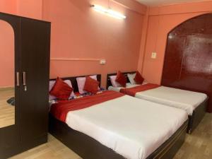 2 Betten in einem rot-weißen Zimmer in der Unterkunft Stay Inn Belle Vue House in Shillong