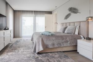 une chambre avec un grand lit et une grande fenêtre dans l'établissement Villa Moroz - BY BEDZY, à Almancil 49 autres photos