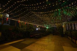 a patio with a string of lights and benches at Quaint Suites Hotel & Banquet in Mumbai