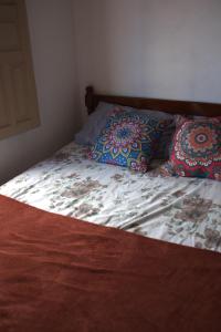 uma cama com duas almofadas num quarto em MangaMel Hostel em Lençóis