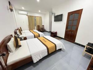 pokój hotelowy z 3 łóżkami i telewizorem w obiekcie KHÁCH SẠN PHƯƠNG DUNG w mieście Dak Rơleang