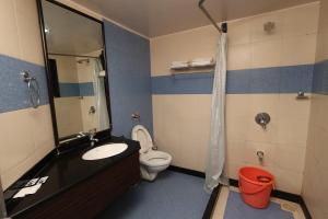 a bathroom with a sink and a toilet at Quaint Suites Hotel & Banquet in Mumbai