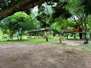 ein Park mit einer Bank und einem Vogelhaus in der Unterkunft Chácara Manjedoura in Ji-Paraná