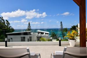 a patio with chairs and a view of the ocean at Penthouse de la plage, private lift in Belle Mare