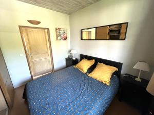 1 dormitorio con cama con colcha azul y espejo en Relais de Poste des Templiers en Jouaignes