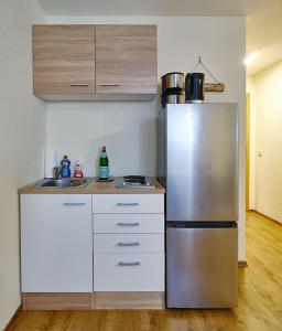 a kitchen with a stainless steel refrigerator and white cabinets at Komfort Appartement Moers-Repelen - Ruhige Lage - Sackgasse in Moers