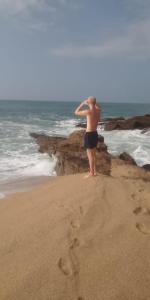 a man standing on the beach looking at the ocean at Sea Face Rest Hambantota in Hambantota