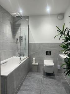La salle de bains est pourvue d'une baignoire, de toilettes et d'un lavabo. dans l'établissement Relaxing 1 bedroom garden flat., à Brentwood