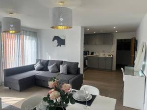 a living room with a couch and a table at Relaxing 1 bedroom garden flat. in Brentwood