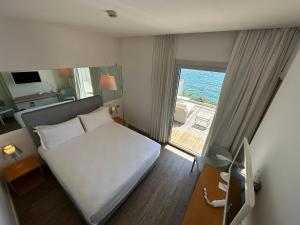 a bedroom with a bed and a view of the ocean at Hotel Miramare - Adults Only in Trieste