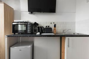 a kitchen with a counter top with a microwave at Archway Station Studios - Double bed in London