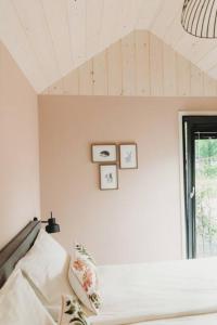 a bedroom with a bed and three clocks on the wall at Knus I Tiny house op de Veluwe in Epe