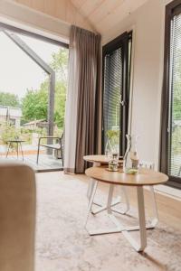 a living room with a table and a large window at Knus I Tiny house op de Veluwe in Epe