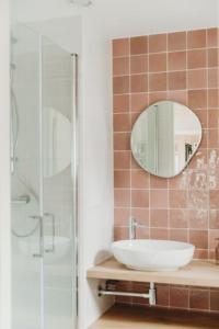 La salle de bains est pourvue d'un lavabo, d'une douche et d'un miroir. dans l'établissement Knus I Tiny house op de Veluwe, à Epe