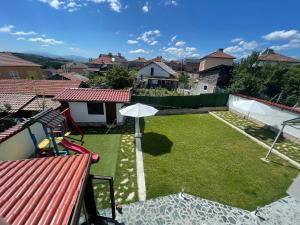 podwórko z parasolem i trawnik z domami w obiekcie Bóris House w mieście Ognianowo