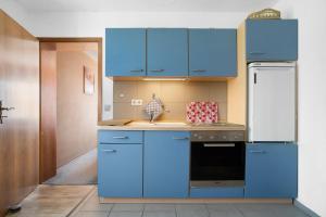 a kitchen with blue cabinets and a black dishwasher at Ferienwohnung Lüssow 