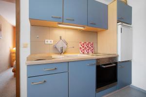 a kitchen with blue cabinets and a sink at Ferienwohnung Lüssow 