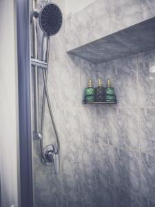 een douche met drie flessen op een plank in een badkamer bij Darlyn Suite Room Sotto Il Castello Love Hotel 5 Stelle in Pavone Canavese