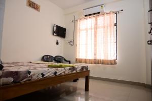 a room with a bed and a window with at Jankivihar Homestay at Prahladghat within 1km from Shri Ram Mandir in Ayodhya