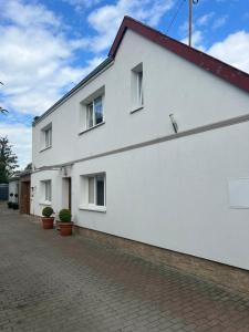 a white building with windows on a brick street at POKÓJ POMORSKA in Elblag