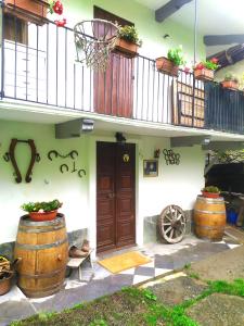 a house with two large wooden barrels and a balcony at La Ghita in Sparone
