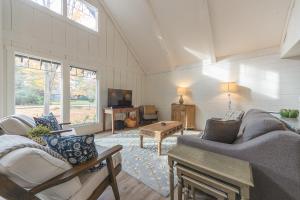 a living room with two couches and a tv at Belacasa - Hot tub and within walking distance to Douglas Beach! in Douglas