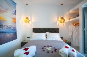 a bedroom with a bed with towels on it at Elvis’ Home in Fira +26 photos