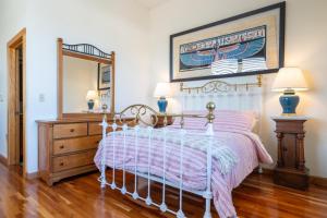 Schlafzimmer mit einem Bett und einem Spiegel in der Unterkunft Colonial 1 - studio apartment overlooking the Black River in South Haven