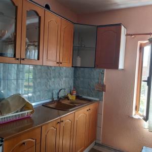 eine Küche mit Holzschränken und einem Waschbecken in der Unterkunft Guest House Pogradeci in Pogradec