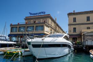 a white boat docked in the water in front of a building at GreRos Yacht by ClaPa H.&G Group in Naples