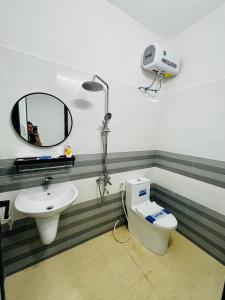 a bathroom with a sink and a toilet and a mirror at Homestay Phủ Cam in Thôn Trường Giang