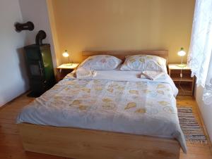 a bedroom with a bed with two lamps on two tables at Rooms Roza in Slunj