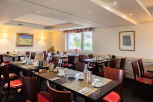 um restaurante com mesas e cadeiras num quarto em Novum Hotel Garden Bremen - Apartments em Bremen