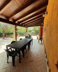 eine Terrasse mit einem schwarzen Tisch und Bänken auf einer Terrasse in der Unterkunft Villa Azzurra Fronte Mare in Capitana