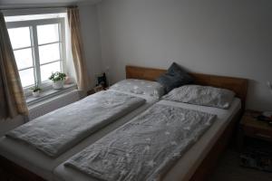 two beds sitting next to a window in a bedroom at Urlaub im Alten Apfelgarten - Ferienwohnung Kastanienterrasse in Sörup +3 photos