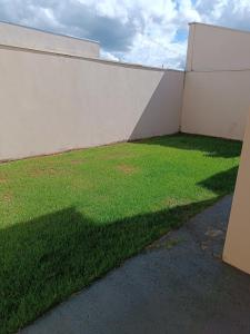 una pared con un campo verde de hierba al lado en Casa flor, en São João Batista do Glória