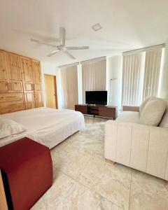 - une chambre avec un lit blanc et un canapé dans l'établissement Casa Isidra, à Rivera