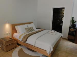 a bedroom with a large bed with a wooden frame at Olympus Stone Lodge in Litochoro