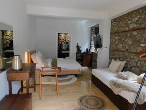 a bedroom with two beds and a desk and a table at Olympus Stone Lodge in Litochoro