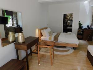 a bedroom with a bed and a table and a desk at Olympus Stone Lodge in Litochoro