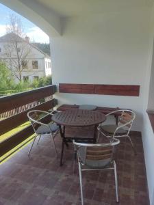 einen Holztisch und Stühle auf einer Terrasse mit einem Fenster in der Unterkunft Ubytování Pod hradem Dobronice 111 in Dobronice
