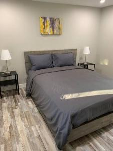 a bedroom with a large bed with two tables and two lamps at ENTIRE 2 BEDROOM APARTMENT DOWNTOWN - u5 in Waterloo