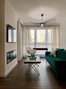 ein Wohnzimmer mit einem grünen Sofa und einem Tisch in der Unterkunft Apartment Business Szyndzielnia in Bielsko-Biała